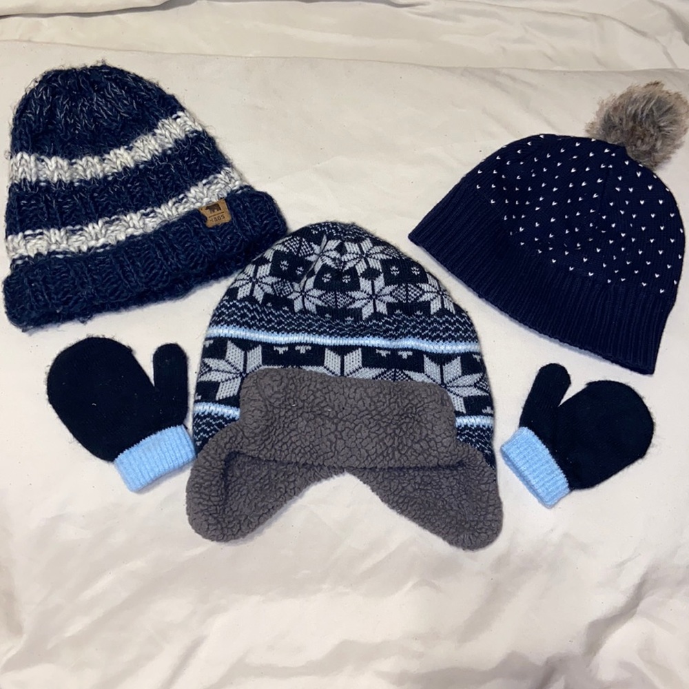 Three navy blue beanie hats and a pair of gloves